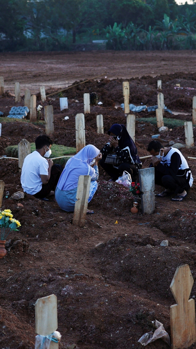 Warga berziarah di dekat pusara keluarganya di area pemakaman khusus COVID-19 di Bekasi, Jawa Barat, Selasa (27/7). Foto: Willy Kurniawan/REUTERS
