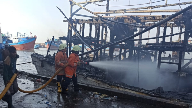 Petugas pemadam kebakaran memadamkan kapal  yang terbakar di Pelabuhan Muara Baru, Rabu (28/7). Foto: Dok. Istimewa