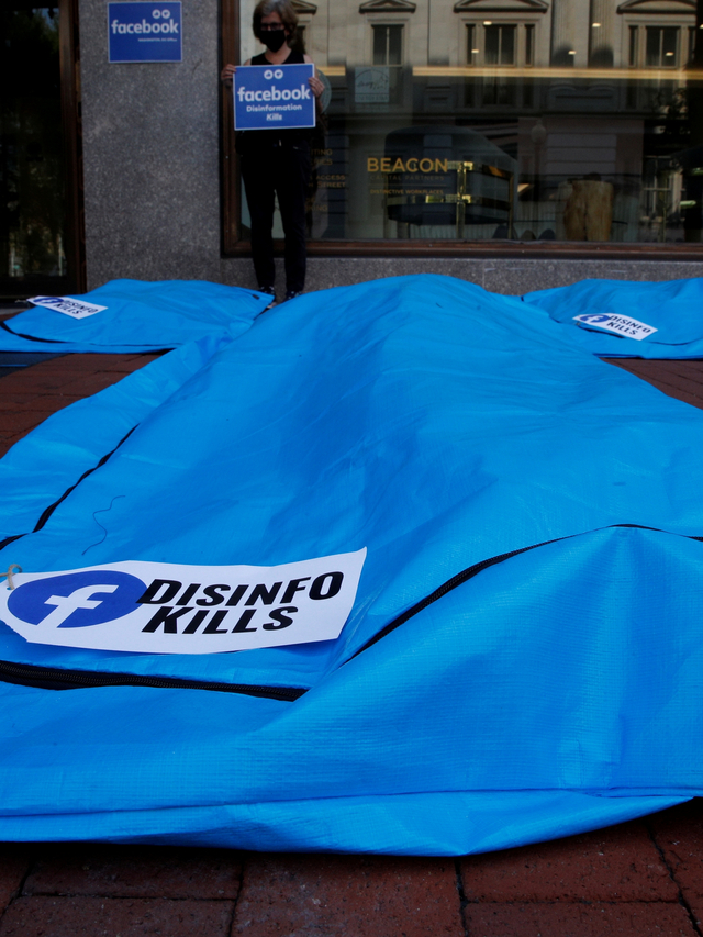 Demonstran berdiri di belakang instalasi kantong mayat selama protes terhadap disinformasi terkait COVID-19 di depan markas besar Facebook di Washington, AS, Rabu (28/7). Foto: Jim Bourg/REUTERS