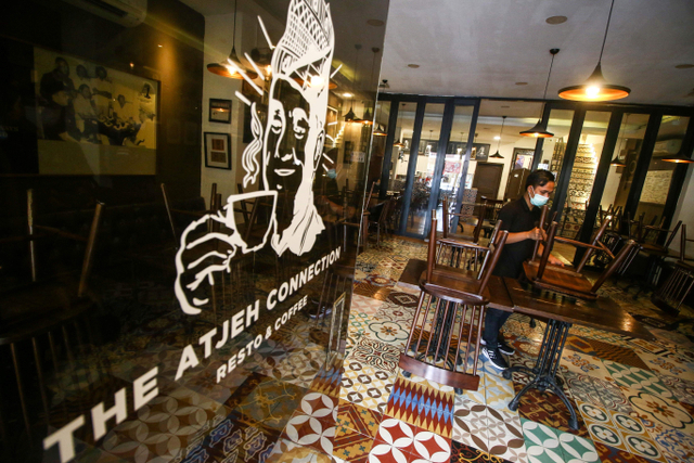 Pekerja merapikan kursi di salah satu restoran di Jakarta, Kamis (29/7/2021). Foto: Rivan Awal Lingga/Antara Foto