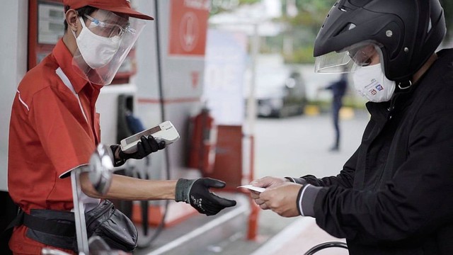 Warga melakukan transaksi digital dibantu petugas SPBU Pertamina Foto: CIKA Indonesia