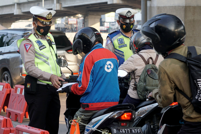 Polisi mengecek surat milik masyarakat di pos penyekatan pertigaan Lampiri, Kalimalang, Jakarta Timur. Foto: Iqbal Firdaus/kumparan