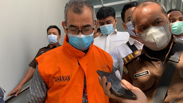 BUPATI Kuantan Singingi (Kuansing) 2016-2021, Mursini, mengenakan rompi orange saat dibawa ke mobil tahanan usai diperiksa selama empat jam oleh penyidik Kejaksaan Tinggi (Kejati) Riau, Kamis (5/8/2021).