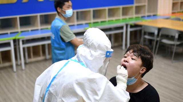 Petugas medis mengambil swab dari warga untuk pengujian COVID-19 di Wuhan, provinsi Hubei, China. Foto: China Daily via REUTERS