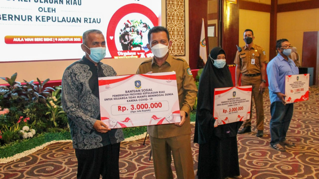 Gubernur Kepri, Ansar Ahmad menyerahkan bantuan secara simbolis ke keluarga yang meninggal akibat COVID-19. Foto: Ismail/kepripedia.com