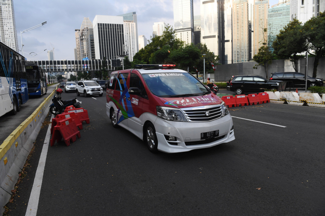 Ambulan melintasi penyekatan PPKM di Jalan Jenderal Sudirman, Jakarta, Senin (9/8).  Foto: Akbar Nugroho Gumay/ANTARA FOTO