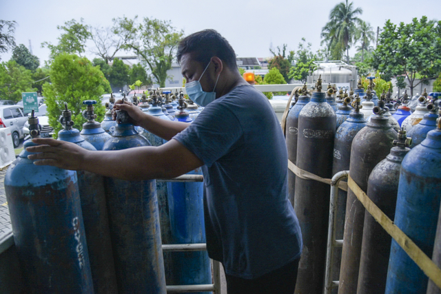 Pekerja mengangkut tabung oksigen medis untuk didistribusikan kesejumlah Rumah Sakit di Kota Medan, Sumatera Utara, Senin (9/8).  Foto: Fransisco Carolio/ANTARA FOTO