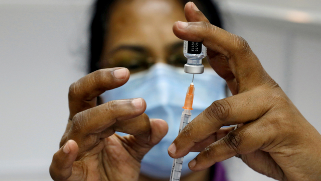 Seorang pekerja medis menyiapkan jarum suntik di pusat vaksinasi COVID-19 di Singapura. Foto: Edgar Su/REUTERS