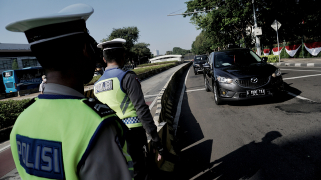 Polisi mengatur lalu lintas saat penerapan Ganjil Genap di Bundaran Senayan, Jakarta, Kamis (12/8). Foto: Jamal Ramadhan/kumparan
