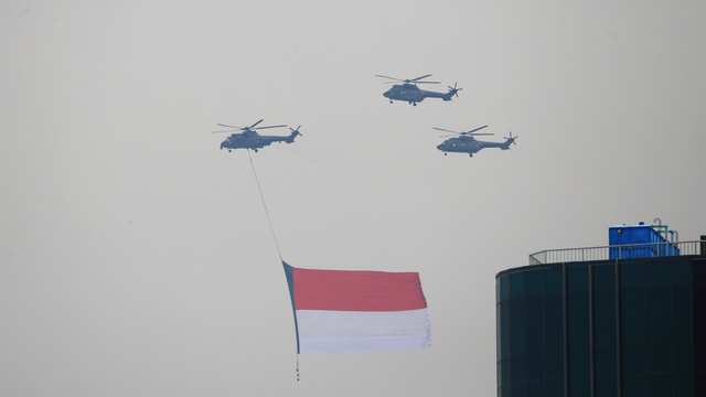 Helikopter TNI AU yang membawa bendera raksasa melakukan gladi resik flypass menjelang upacara Hari Ulang Tahun Kemerdekaan RI ke-76. Foto: Aditia Noviansyah/kumparan