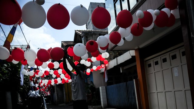 Warga memasang hiasan balon merah putih di Gang Cikondang, Coblong, Bandung, Jawa Barat, Sabtu (14/8/2021). Foto: Raisan Al Farisi/ANTARA FOTO
