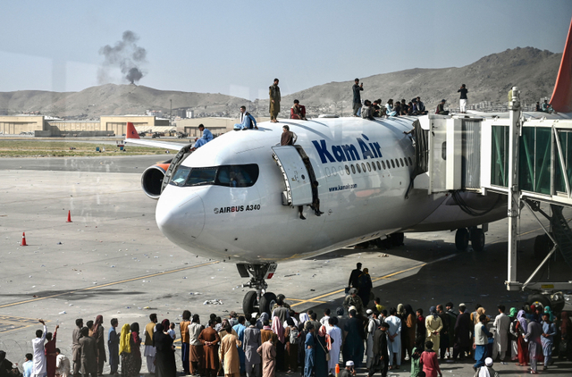 Orang-orang Afghanistan naik ke atas sebuah pesawat saat mereka menunggu di bandara Kabul di Kabul pada 16 Agustus 2021. Foto: WAKIL KOHSAR / AFP)