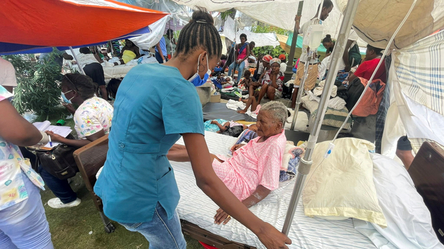Seorang wanita dirawat oleh anggota tenaga medis di luar rumah sakit setelah gempa berkekuatan 7,2, di Les Cayes, Haiti, Senin (16/8). Foto: Ricardo Arduengo/REUTERS