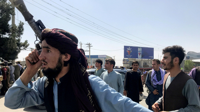 Seorang anggota pasukan Taliban memeriksa area di luar Bandara Internasional Hamid Karzai di Kabul, Afghanistan, Senin (16/8). Foto: Stringer/REUTERS