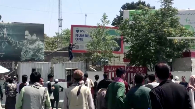 Seorang pejuang Taliban memegang senjata sambil berdiri di sebuah gedung di luar bandara Kabul, Kabul, Afghanistan, Senin (16/8). Foto: REUTERS TV/via REUTERS