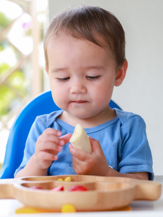 Ilustrasi bayi makan pisang. Foto: Shutter Stock