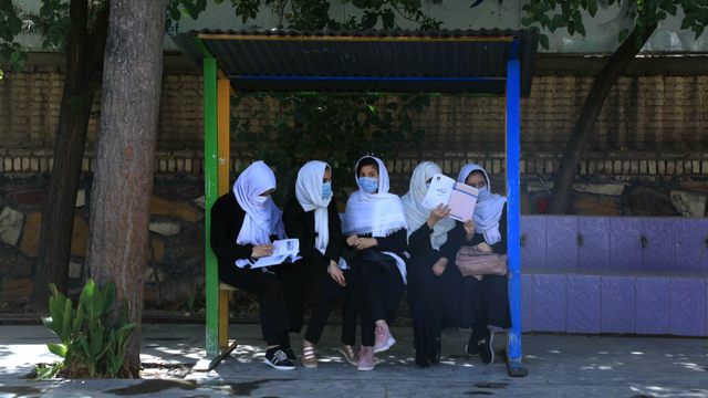 Para siswi duduk di halaman sekolah di Herat. Foto: Aref Karimi / AFP