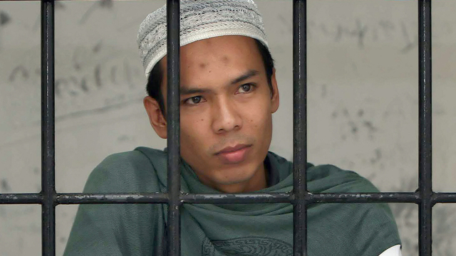 Verry Idham Heryansyah, juga dikenal sebagai Ryan, di balik jeruji sebelum menjalani persidangan. Foto: Novi/AFP