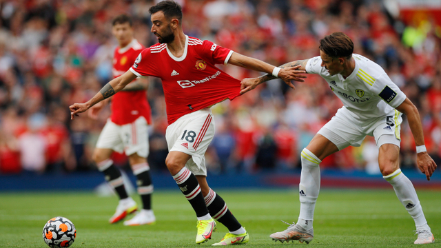 Pemain Manchester United Bruno Fernandes beraksi dengan Robin Koch dari Leeds United pada pertandingan Premier League antara Manchester United melawan Leeds United di Old Trafford, Manchester, Inggris - 14 Agustus 2021. Foto: Phil Noble/Reuters