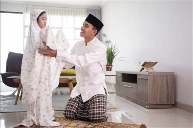 Ilustrasi ayah yang sedang mengajari anaknya sholat. https://www.freepik.com/