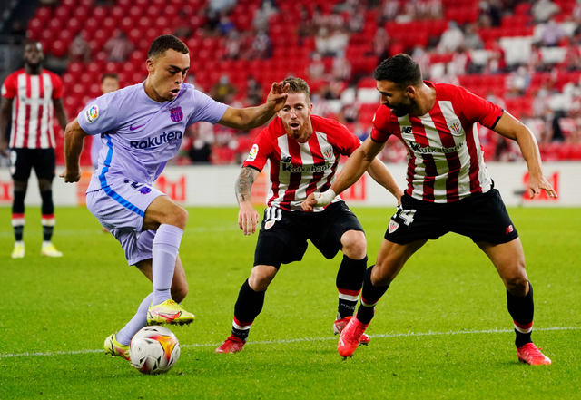 Sergino Dest FC Barcelona beraksi dengan Mikel Balenziaga dan Iker Muniain dari Athletic Bilbao saat pertandingan LaLiga di San Mames, Bilbao, Spanyol. Foto: Vincent West/Reuters