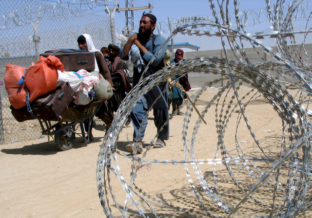 Sebuah keluarga Afghanistan melewati titik persimpangan Gerbang Persahabatan di kota perbatasan Chaman, Pakistan Kamis (19/8/2021). Foto: Saeed Ali Achakzai/Reuters