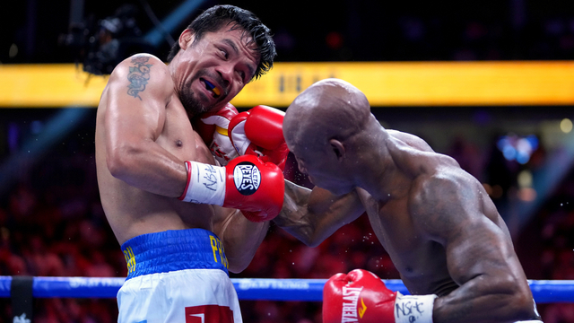 Manny Pacquiao (kiri) melawan Yordenis Ugas dalam pertarungan kejuaraan kelas welter dunia di T-Mobile Arena, Las Vegas, Nevada, Sabtu (21/8). Foto: Stephen R. Sylvani-USA TODAY Sports via REUTERS