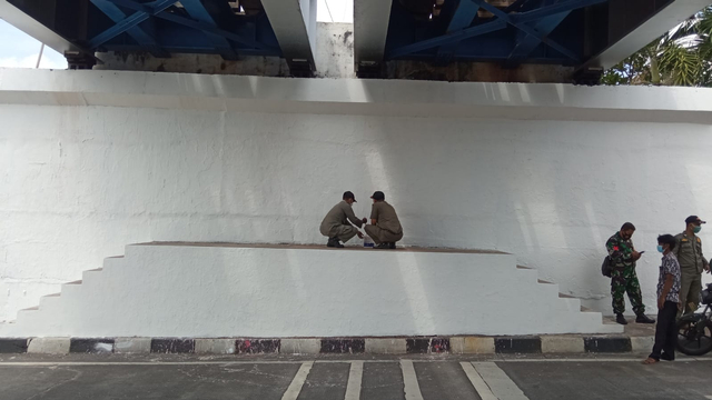 Petugas Satpol PP Kota Yogya menghapus mural di bawah Jembatan Kleringan Kewek, Danurejan, Kota Yogyakarta. Foto: Arfiansyah Panji Purnandaru/kumparan