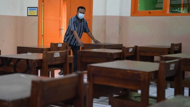 Pekerja menata bangku di ruang kelas sekolah di SMA Negeri 87, Jakarta, Selasa (24/8/2021). Foto: Hafidz Mubarak A/ANTARA FOTO