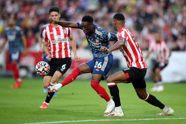 Pemain Arsenal Folarin Balogun berusaha melewati pemain Brentford Ethan Pinnock pada pertandingan Premier League di Stadion Brentford Community, London, Inggris. Foto: Peter Cziborra/REUTERS