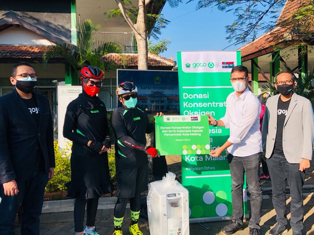 Head Public Policy & Government Relations Gojek wilayah Jawa Timur, Boy Arno, bersama dengan Wali Kota Malang, Drs H Sutiaji, dengan didampingi oleh District Head Gojek Malang, Nur Andriansyah (kiri), dan District Ops Manager Gojek Malang, Noviadi Suryadarma (kanan), dalam acara serah terima bantuan alat konsentrator oksigen kepada Pemerintah Kota Malang sebagai bagian dukungan #bangkitbersama dalam menangani COVID-19. Foto: dok