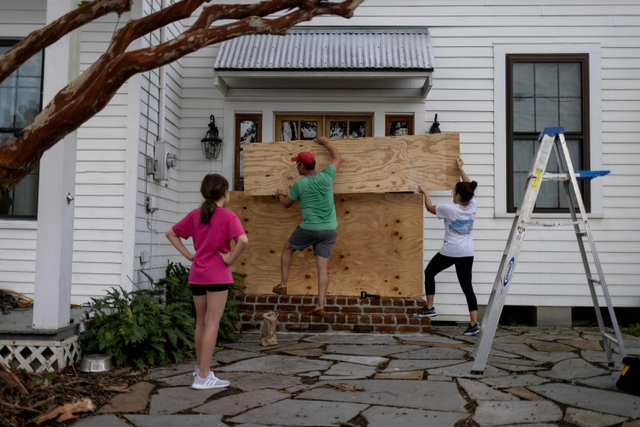 Warga menutup jendela rumah mereka dekan papan untuk menghadapi Badai Ida di Morgan City, Louisiana, Amerika Serikat Sabtu (28/8/2021). Foto: Adrees Latif/Reuters