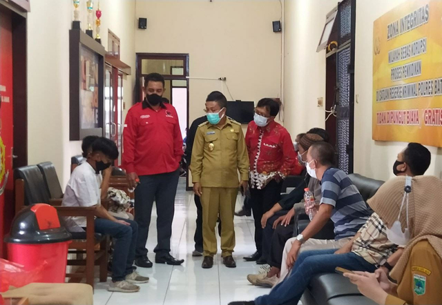 Ketua DPC PDIP Kota Batu, Punjul Santoso (berbaju dinas) saat berdialog dengan pelaku akso vandalisme terhadap baliho Puan Maharani di Polres Batu, Senin (30/8/2021).