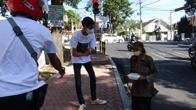 Andan saat memberikan nasi kotak di jalan di Bondowoso bersama timnya. dok