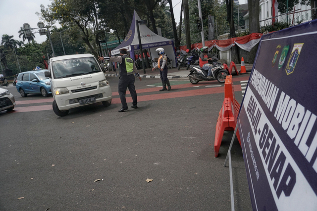 Polisi mengarahkan mobil ber-plat akhir angka genap pada titik ganjil-genap M.H Thamrin di Bundaran Patung Kuda dekat Monas, Rabu (1/9/2021). Foto: Jamal Ramadhan/kumparan