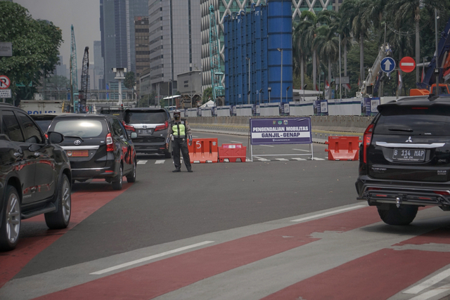 Polisi mengarahkan mobil ber-pelat akhir angka genap pada titik ganjil-genap M.H Thamrin di Bundaran Patung Kuda dekat Monas, Rabu (1/9/2021). Foto: Jamal Ramadhan/kumparan