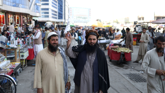 Pendukung Imarah Islam Afghanistan tengah berada di sebuah pasar seraya mengibarkan bendera Taliban di Kabul, Afghanistan, Rabu (1/9). Foto: WANA via REUTERS