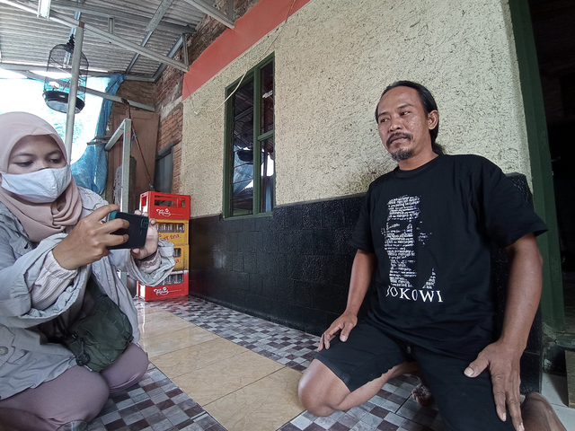 Agus Mujianto (40) memakai kaus yang diperolehnya dari Presiden Jokowi. FOTO: Anatasya/CIREMAITODAY
