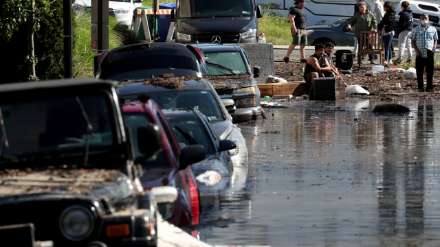 Penduduk setempat berdiri di dekat air banjir setelah badai Ida di Mamaroneck, New York, AS, Kamis (2/9). Foto: Mike Segar/REUTERS