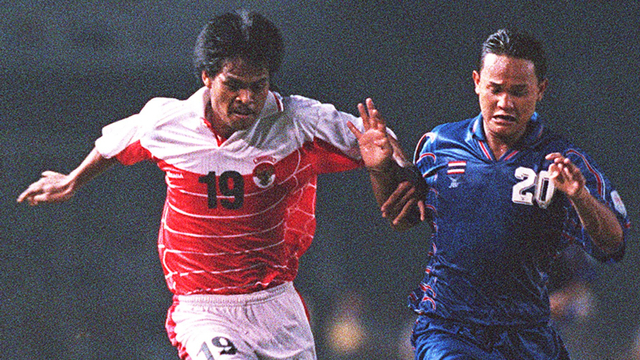 Chaichan Khewsen (kanan) dari Thailand dan Nur'alim dari Indonesia berebut bola pada paruh pertama final sepak bola di Pesta Olahraga Asia Tenggara ke-19. Foto: Romeo Gacad/AFP