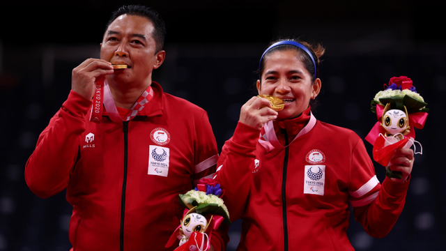 Ganda campuran Indonesia Hary Susanto dan Leani Ratri Oktila merayakan medali emas usai menang di partai final Paralimpiade Tokyo 2020 di Stadion Nasional Yoyogi, Tokyo, Jepang. Foto: Athit Perawongmetha/REUTERS