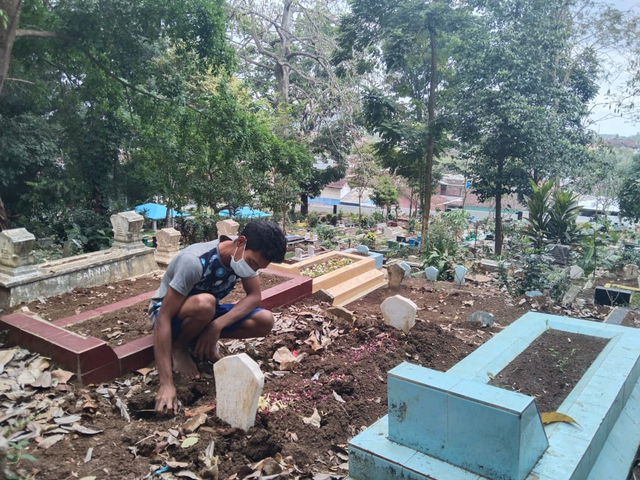 Salah satu penggali kubur di TPU Ngujil. Foto: M Sholeh