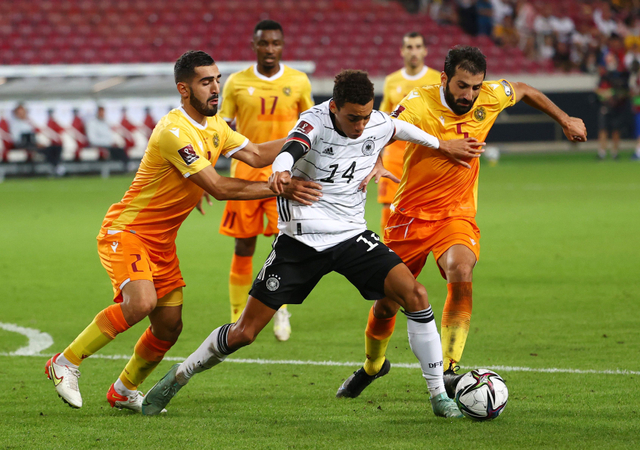 Pemain Jerman Jamal Musiala dihadang pemain Armenia David Terteryan dan Artak Grigoryan saat kualifikasi Piala Dunia di Mercedes-Benz Arena, Stuttgart, Jerman. Foto: Kai Pfaffenbach/Reuters