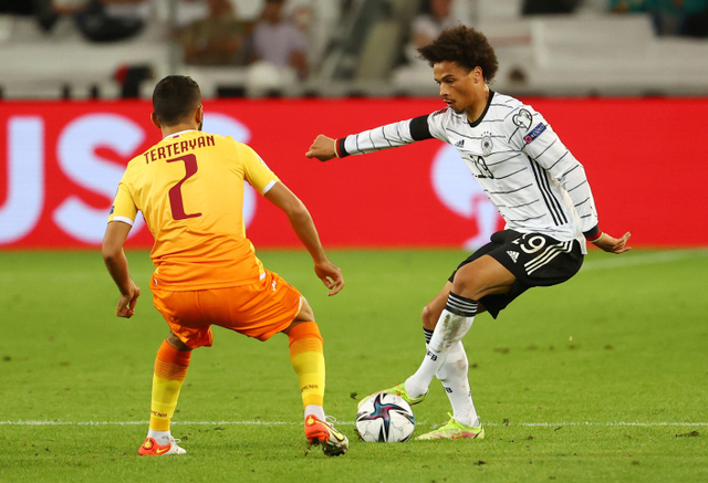 Pemain Jerman Leroy Sane duel dengan pemain Armenia David Terteryan saat kualifikasi Piala Dunia di Mercedes-Benz Arena, Stuttgart, Jerman. Foto: Kai Pfaffenbach/Reuters