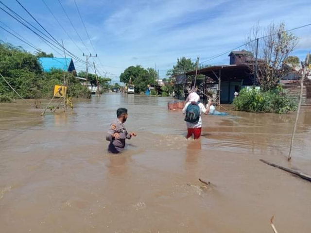 Salah satu anggota polisi saat mengecek kedalaman genangan air di Jalan Trans Kalimantan Kasongan-Kereng Pangi. (FOTO: Dokumen Warga).