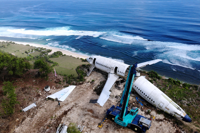 Foto udara aktivitas pengerjaan perakitan badan pesawat bekas di kawasan Pantai Nyang-Nyang, Badung, Bali, Minggu (12/9/2021). Foto: Fikri Yusuf/Antara Foto