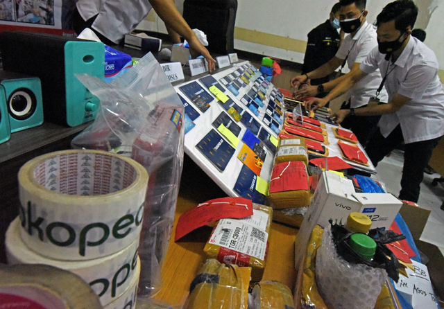 Anggota Ditreskrimsus Polda Banten menunjukkan barang bukti kejahatan perdagangan transaksi elektronik (ITE) saat ekspos di Mapolda Banten, Serang, Banten, Rabu (15/9/2021). Foto: Asep Fathulrahman/Antara Foto