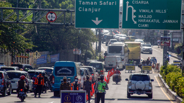 Petugas gabungan Satgas COVID-19 Kabupaten Bogor mengarahkan kendaraan saat penerapan sistem ganjil genap di Jalan Raya Puncak, Gadog, Ciawi, Kabupaten Bogor, Jawa Barat, Sabtu (18/9/2021). Foto: YULIUS SATRIA WIJAYA/ANTARA FOTO