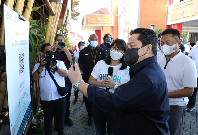 Menteri BUMN Erick Thohir (tengah) didampingi Direktur Utama Telkom Ririek Adriansyah (kanan) melakukan check-in digital dengan scan QR Code PeduliLindungi sebelum memasuki lokasi UMKM saat kunjungan kerja di Denpasar pada Senin, (20/9). Foto: dok. Telkom Indonesia