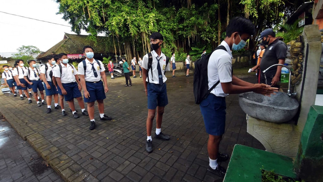 Siswa mencuci tangan saat akan memasuki area sekolah dalam pembelajaran tatap muka (PTM) di SMP Negeri Hindu 2 Sukawati, Gianyar, Bali, Selasa (23/3/2021). Foto: Nyoman Hendra Wibowo/ANTARA FOTO